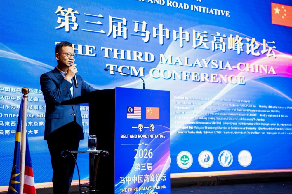 Speaker addressing the hall in front of the main conference backdrop