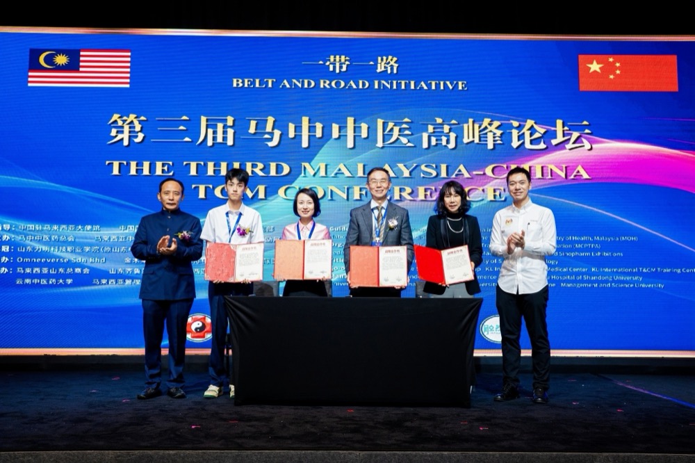 Signatories exchanging Memoranda of Understanding on stage